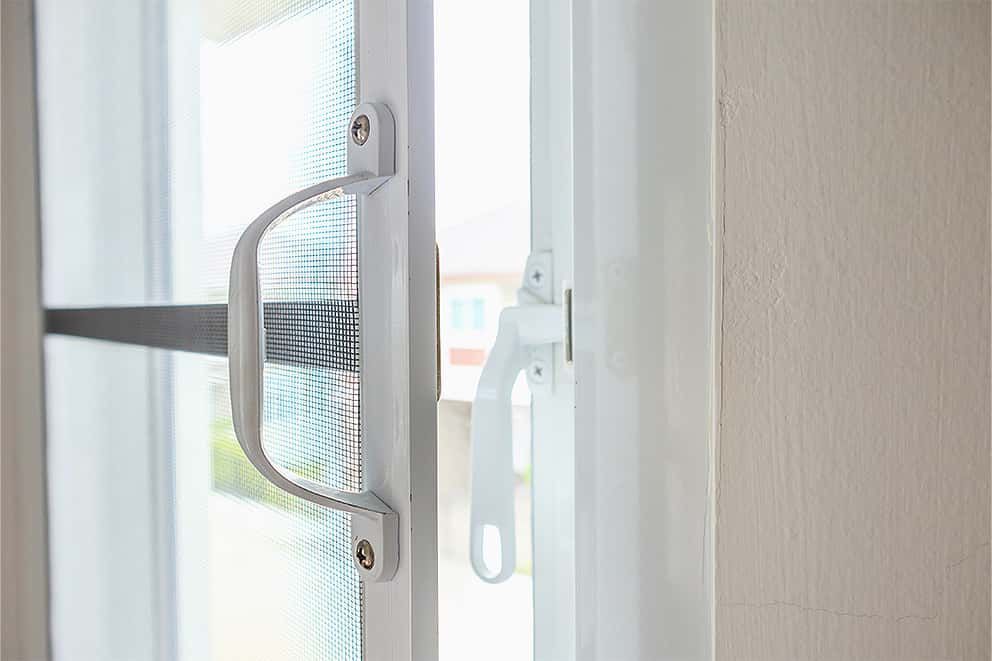 Eine Nahaufnahme einer Glasschiebetür mit einem Griff.