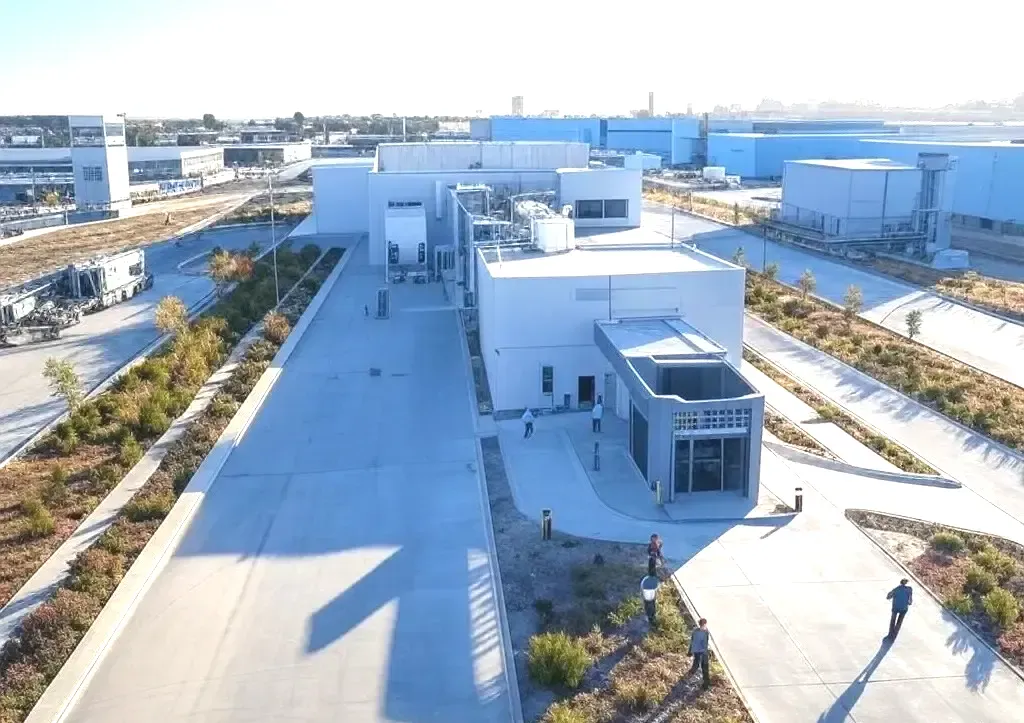 Una vista aérea de un gran edificio blanco en una zona industrial.