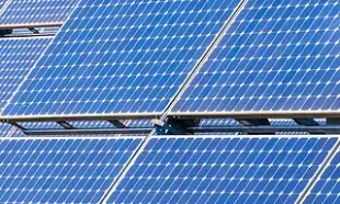 Primer plano de paneles solares azules dispuestos en una cuadrícula, capturando la luz solar para la conversión de energía.