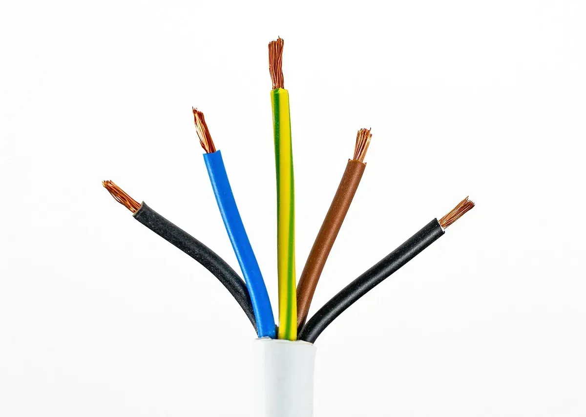 Cinco cables eléctricos con extremos de cobre expuestos, de color negro, azul, marrón, amarillo/verde y otro negro, que se extienden desde un cable blanco.