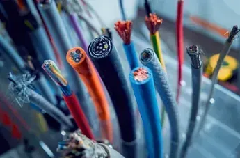 Primer plano de un conjunto de cables eléctricos de colores con hilos de cobre expuestos.