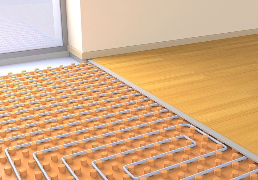 Una habitación con suelo de madera y calefacción por suelo radiante.