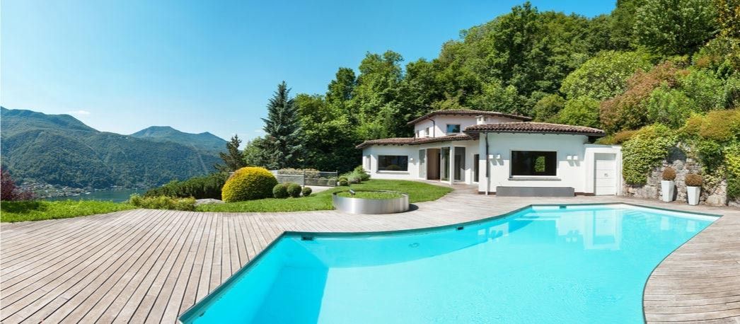 Hay una gran piscina delante de una casa.