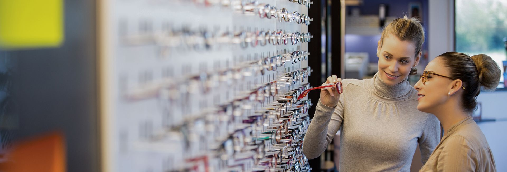 Vendeuse montrant une paire de lunettes à une cliente