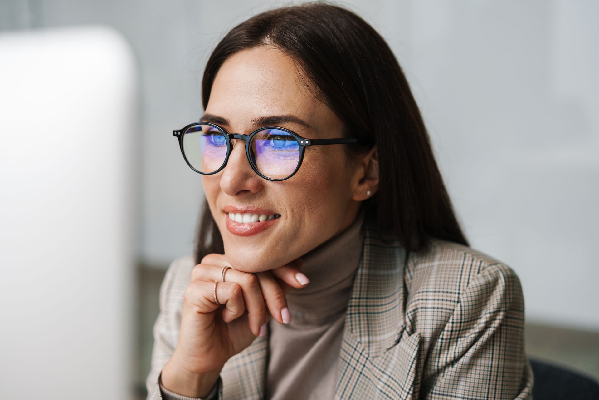 Femme avec lunettes regardant un écran d'ordinateur