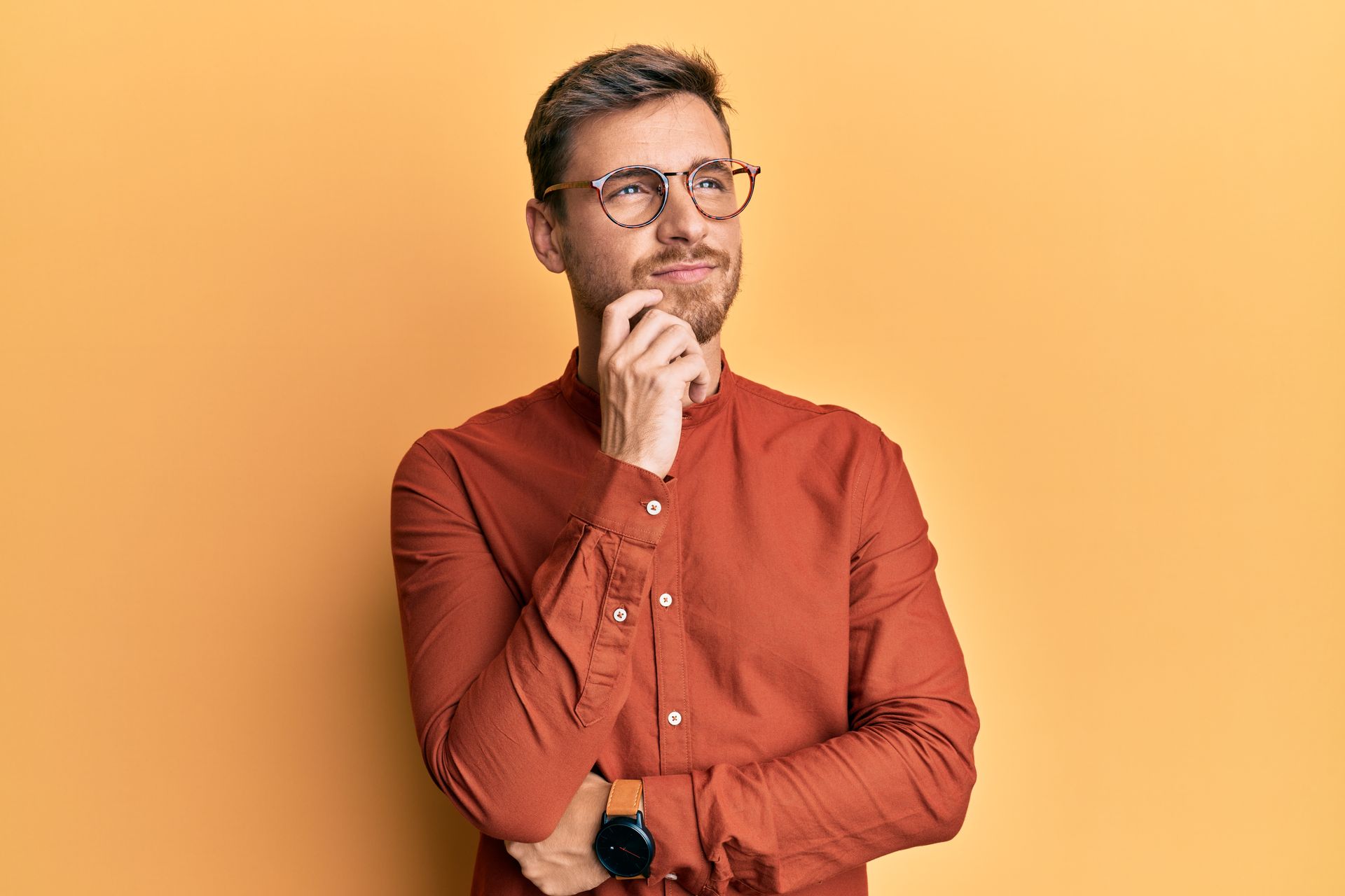 Homme portant des lunettes sur fond orange