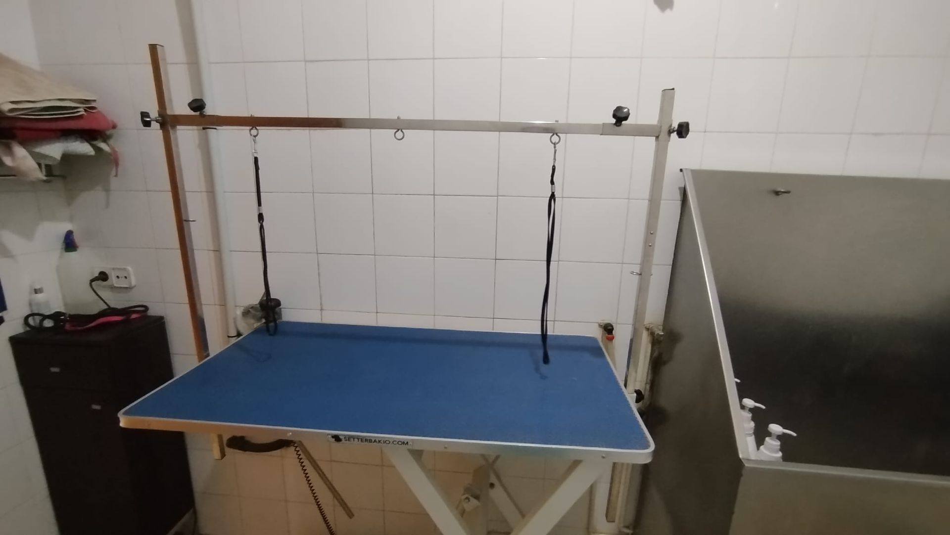 Una mesa azul en una habitación con azulejos blancos.