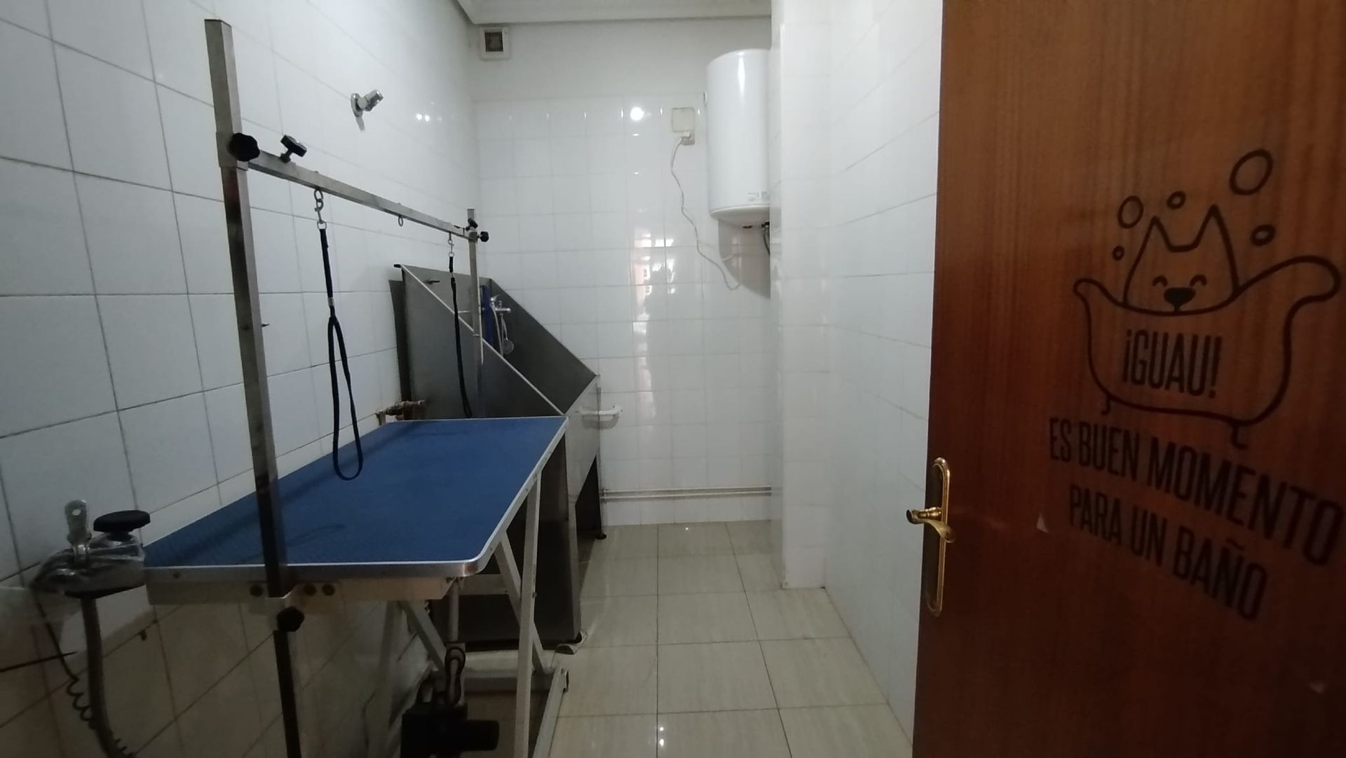 Una habitación con una mesa azul y una puerta que dice aqualux