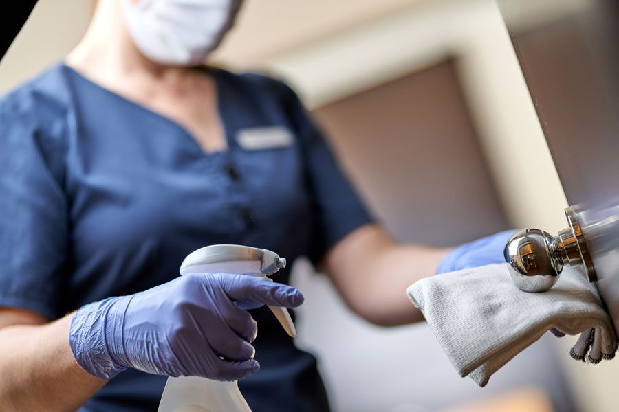 Professionnelle nettoyant une poignée de porte