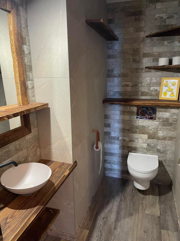 Un homme répare des toilettes avec une clé | Vincent Bourdin Sàrl