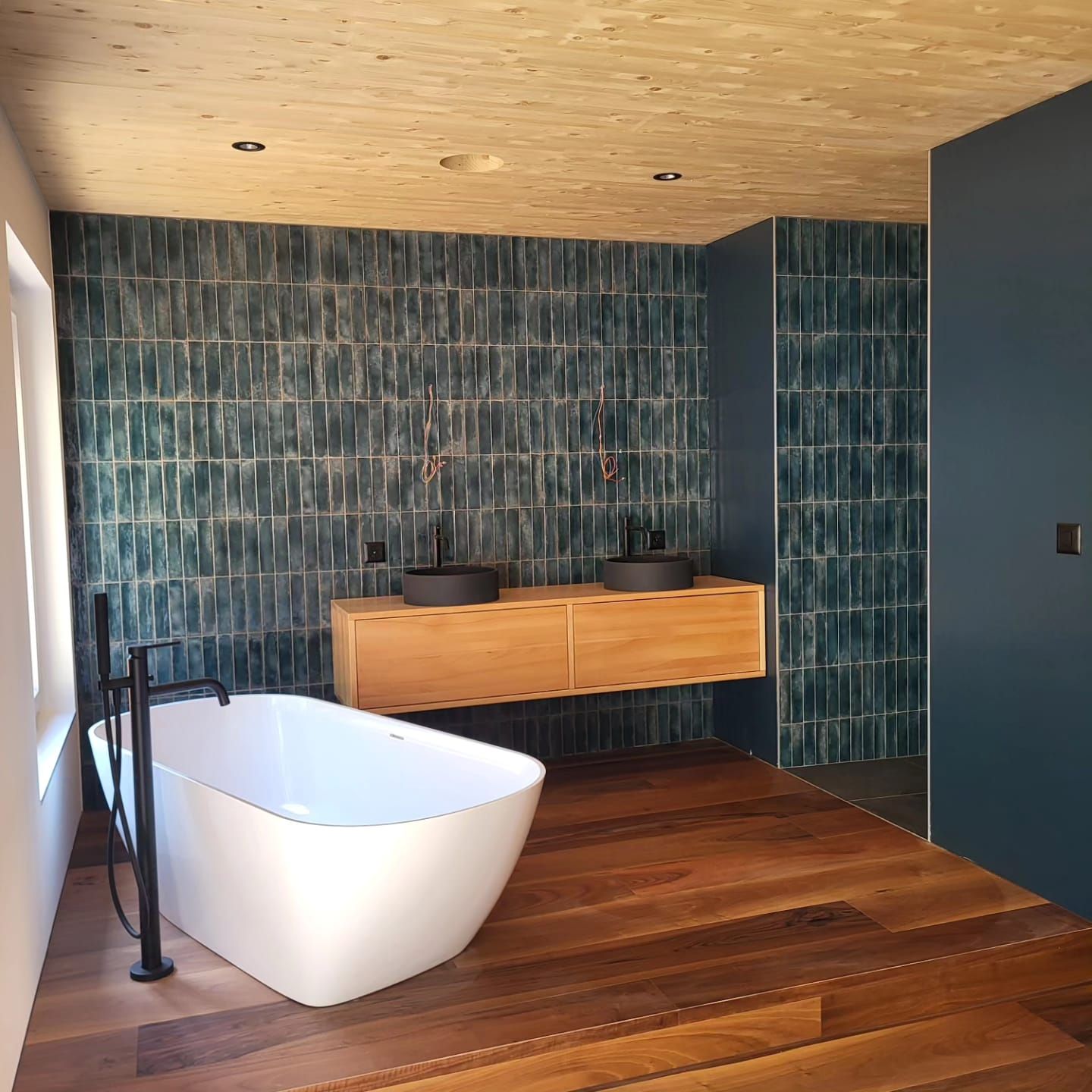 Un lavabo de salle de bain avec un robinet chromé sur un comptoir noir | Vincent Bourdin Sàrl