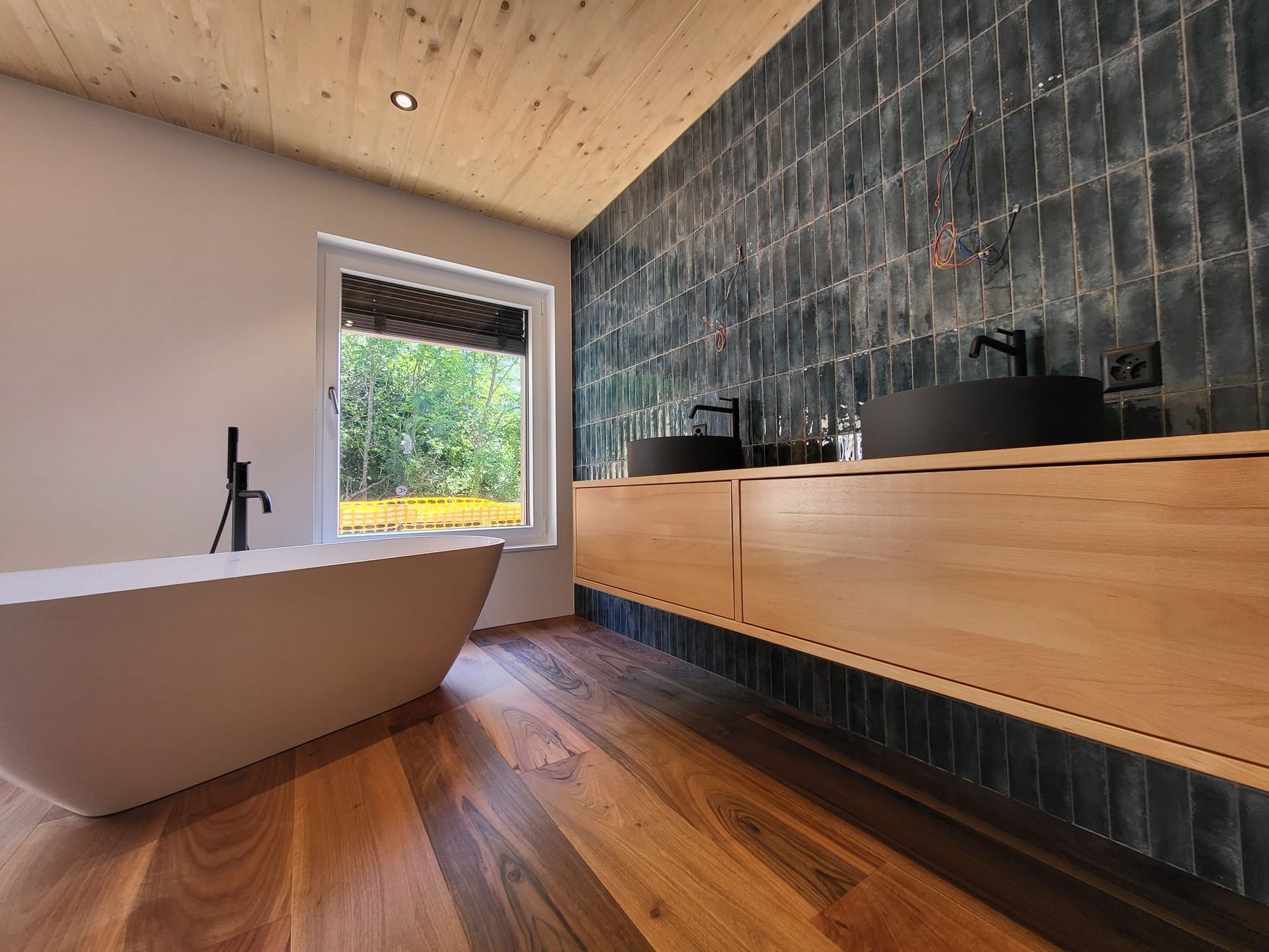 Une salle de bain avec baignoire, lavabos et fenêtre | Vincent Bourdin Sàrl