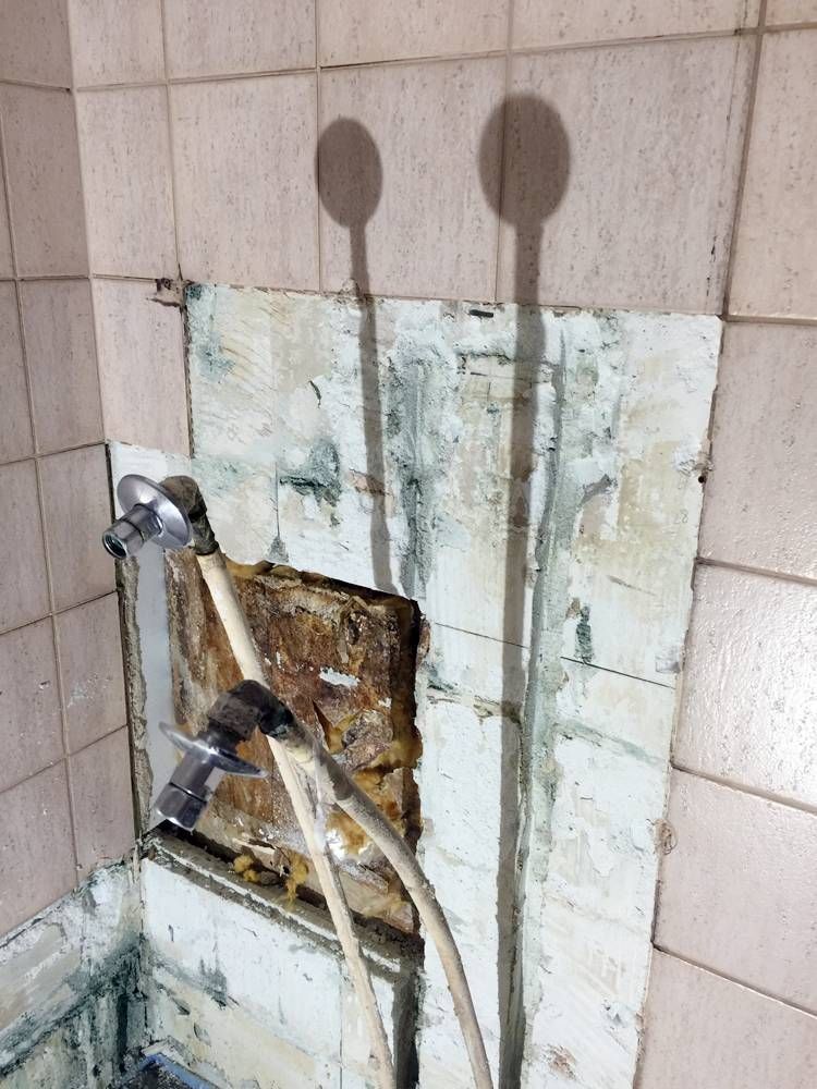 L'ombre d'une pomme de douche est projetée sur un mur carrelé | Vincent Bourdin Sàrl