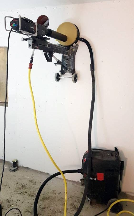 Un carotteur est fixé à une machine sur un mur | Vincent Bourdin Sàrl