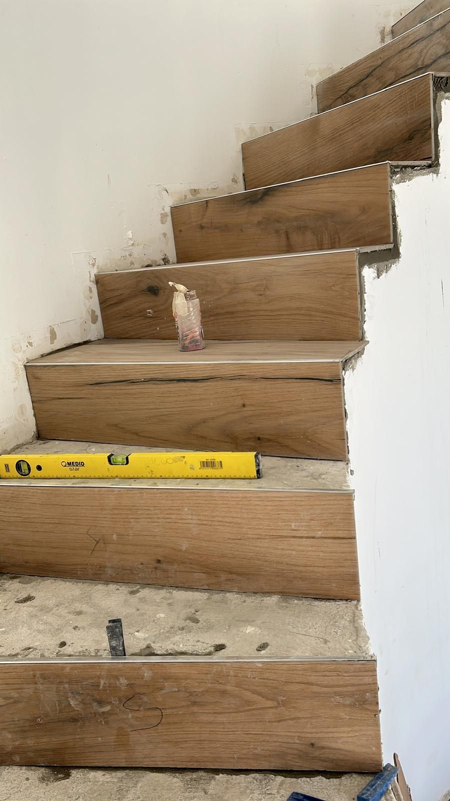 Escalera de madera en construcción con nivel en un escalón.