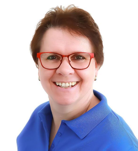 Eine Frau mit Brille und blauem Hemd lächelt