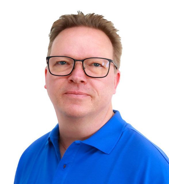 Ein Mann mit Brille und blauem Hemd blickt in die Kamera