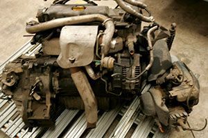 Un motor muy viejo se encuentra sobre un estante de metal.