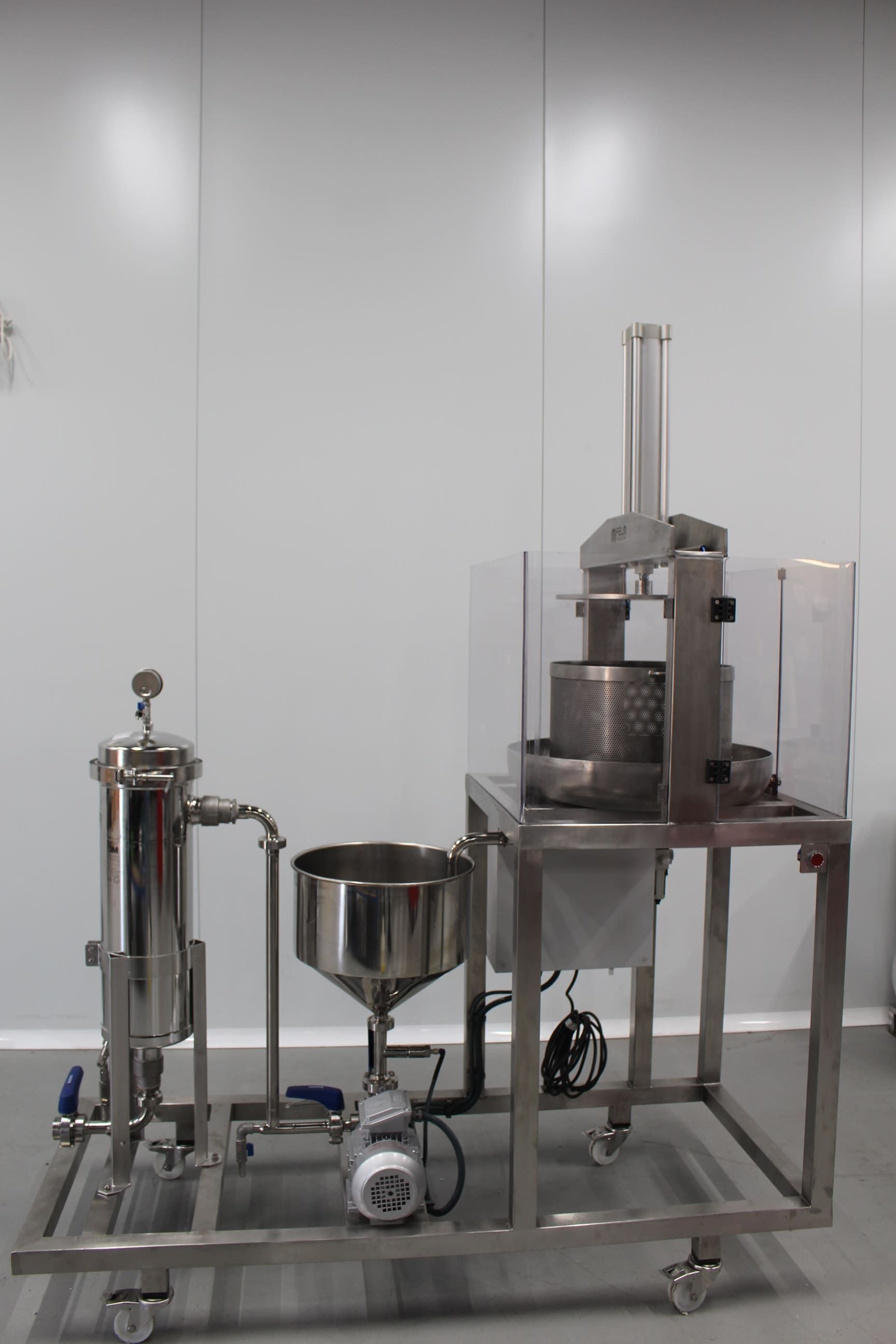 Una máquina de acero inoxidable está colocada sobre un carrito en una habitación.