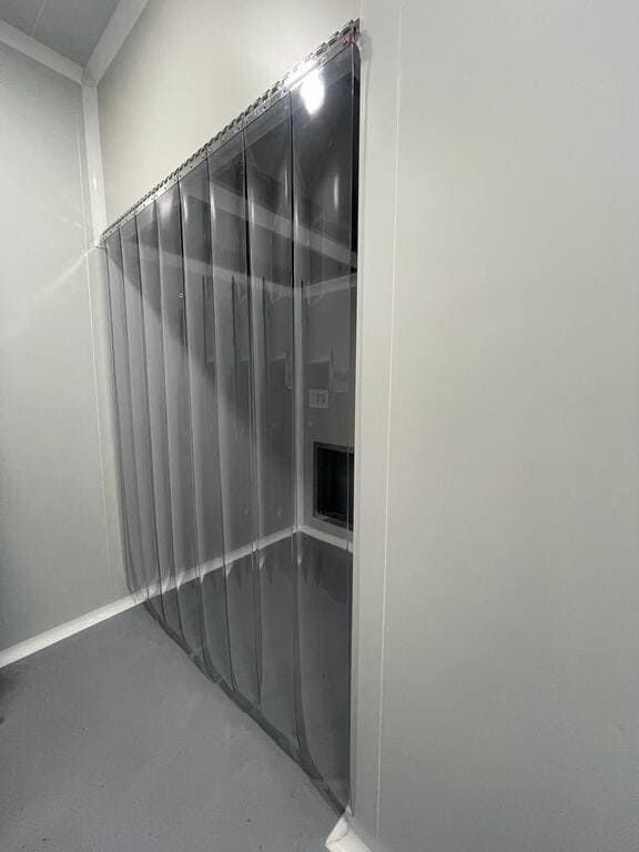 Una habitación con una cortina gris colgada en la pared.