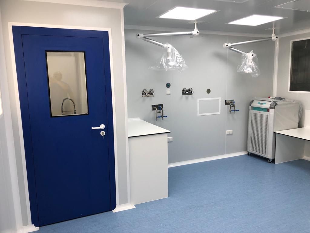 Una habitación con una puerta azul y una ventana.