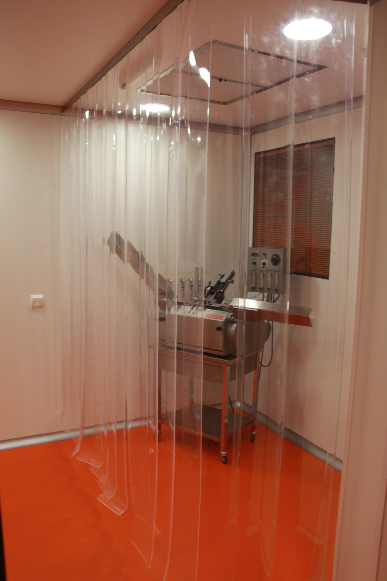 Una habitación con una cortina transparente y un suelo naranja.