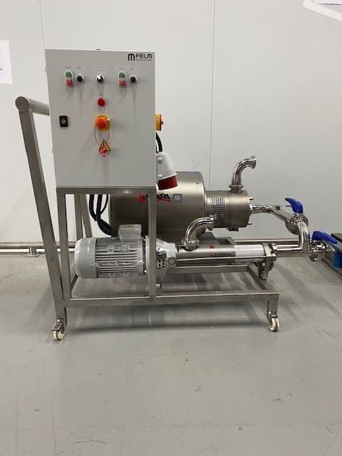 Una máquina de acero inoxidable está en el suelo de una habitación.