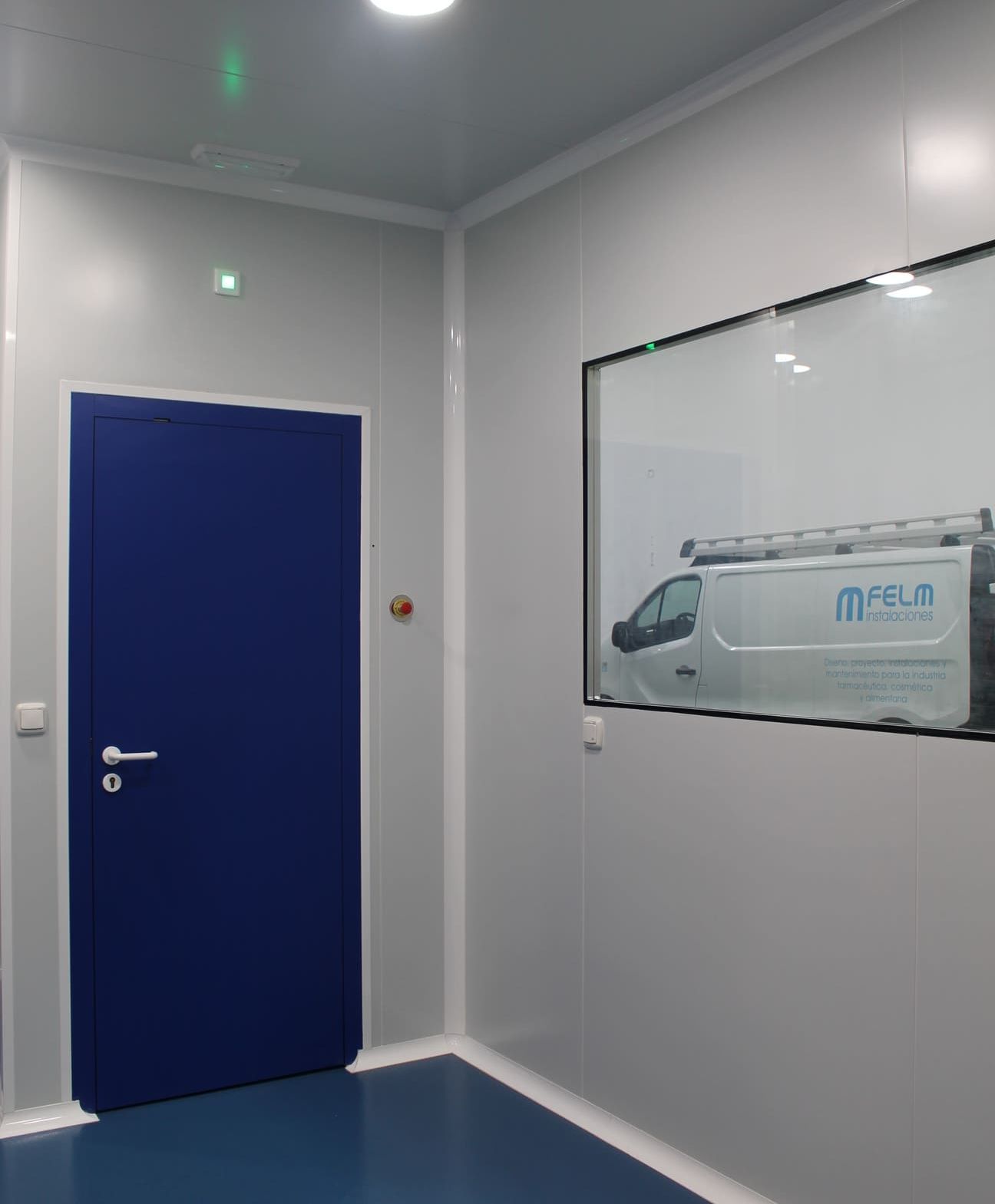 Una habitación con una puerta azul y una imagen de una furgoneta en la pared.