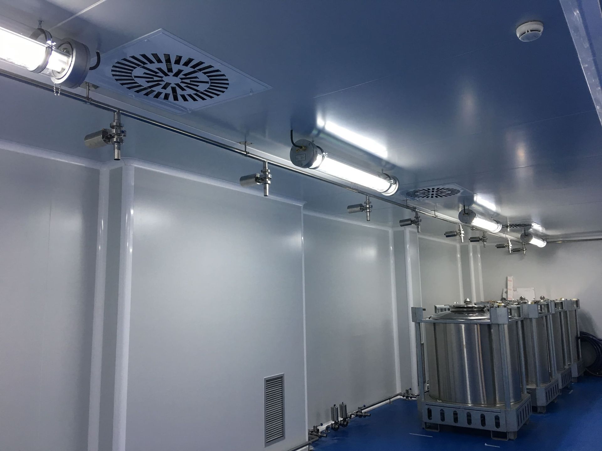 Una habitación con un ventilador de techo y muchos tanques dentro.