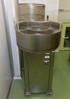 Una máquina de acero inoxidable está colocada sobre un suelo verde en una habitación.