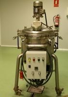 Una gran máquina de acero inoxidable se encuentra sobre un piso verde en una habitación.