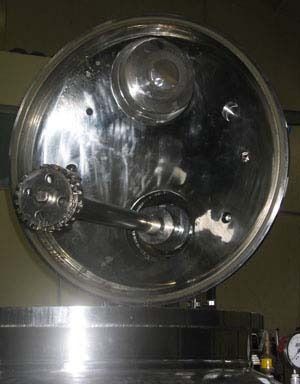 Un primer plano de un tanque de acero inoxidable con la tapa abierta.