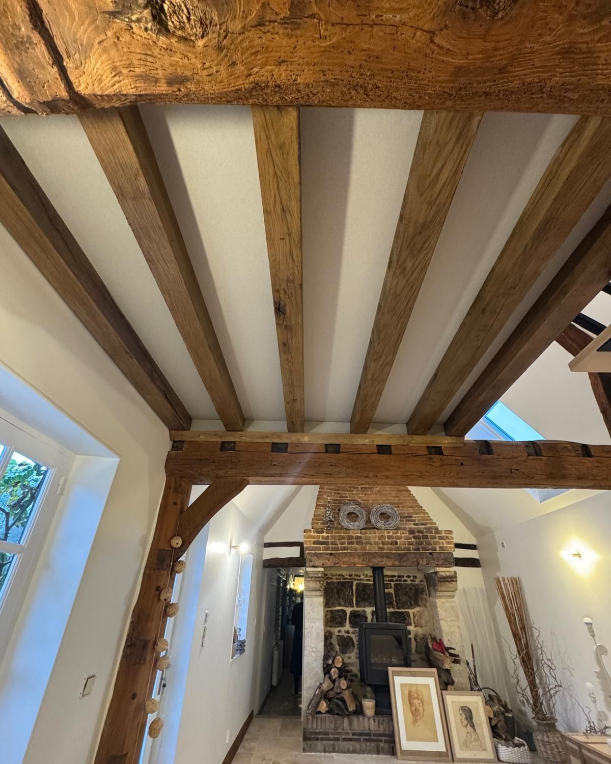 Poutres apparentes sur un plafond blanc.