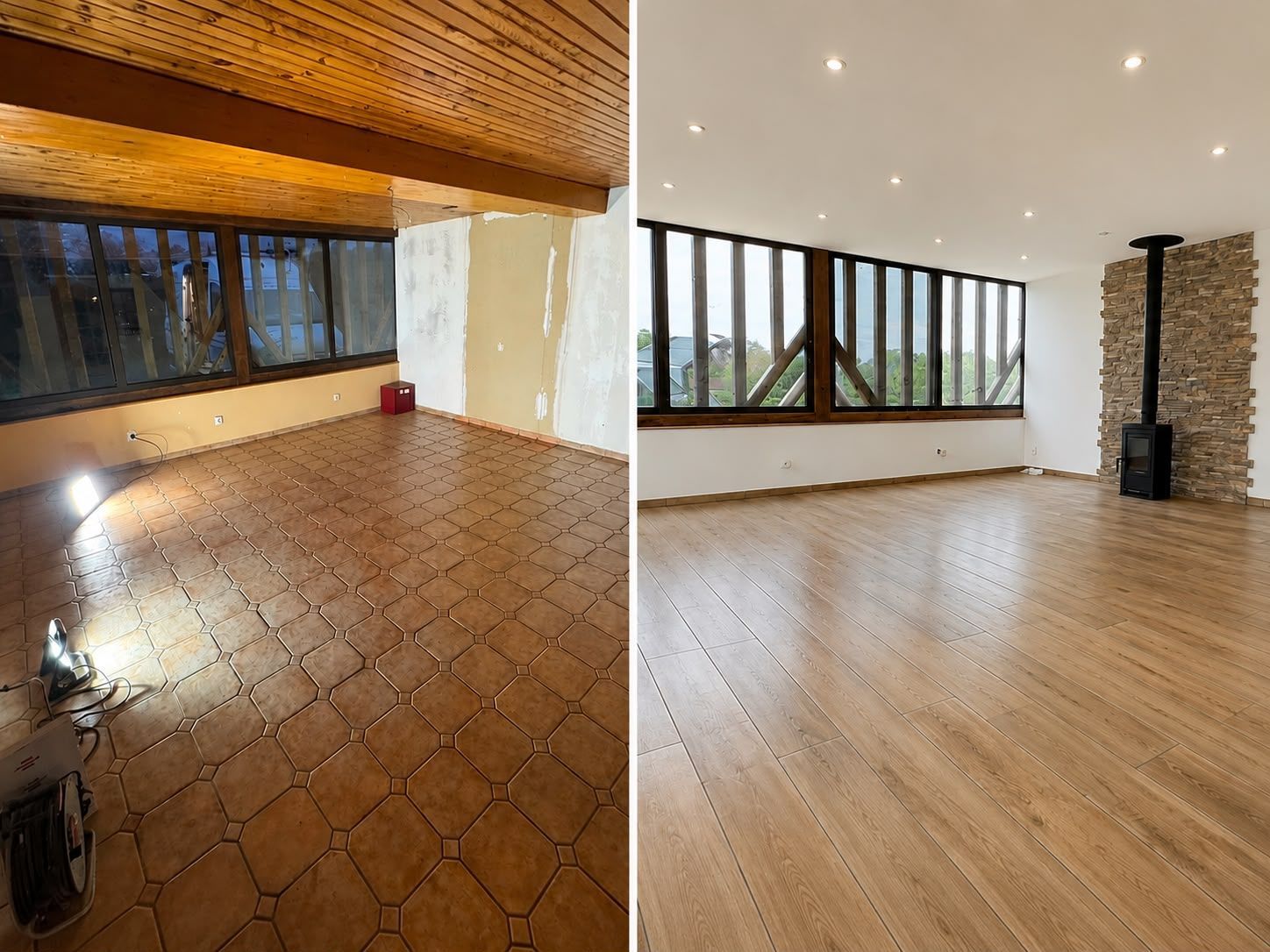 Pièce moderne vide avec parquet, coin carrelé, grandes fenêtres et poêle à bois adossé à un mur en pierre.