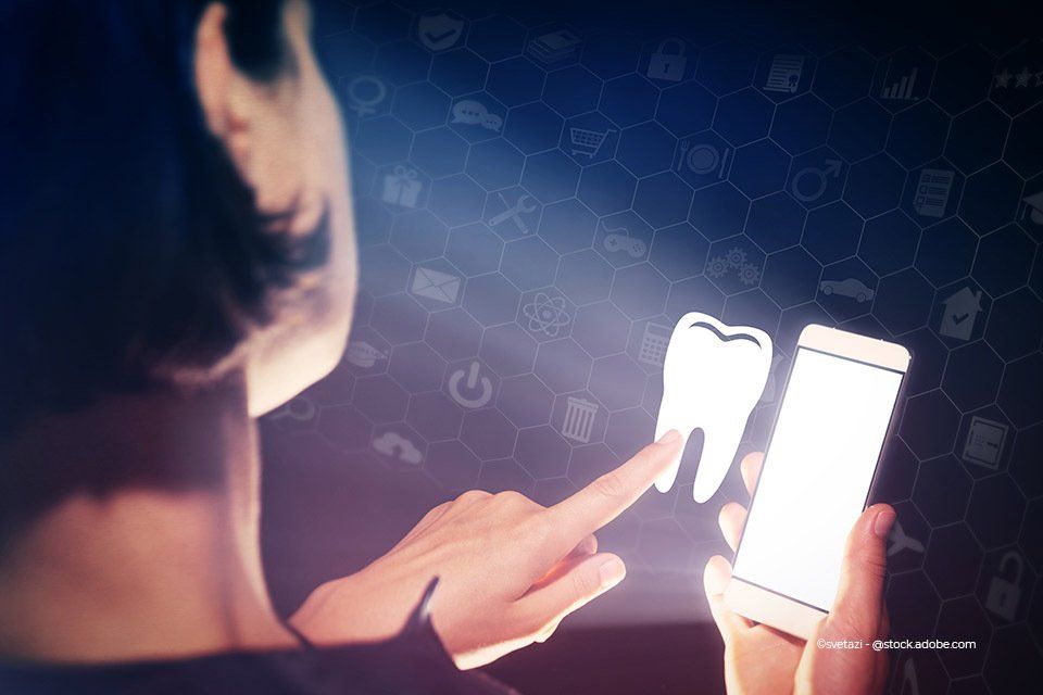 Person wählt Zahn-Icon auf Smartphonedisplay