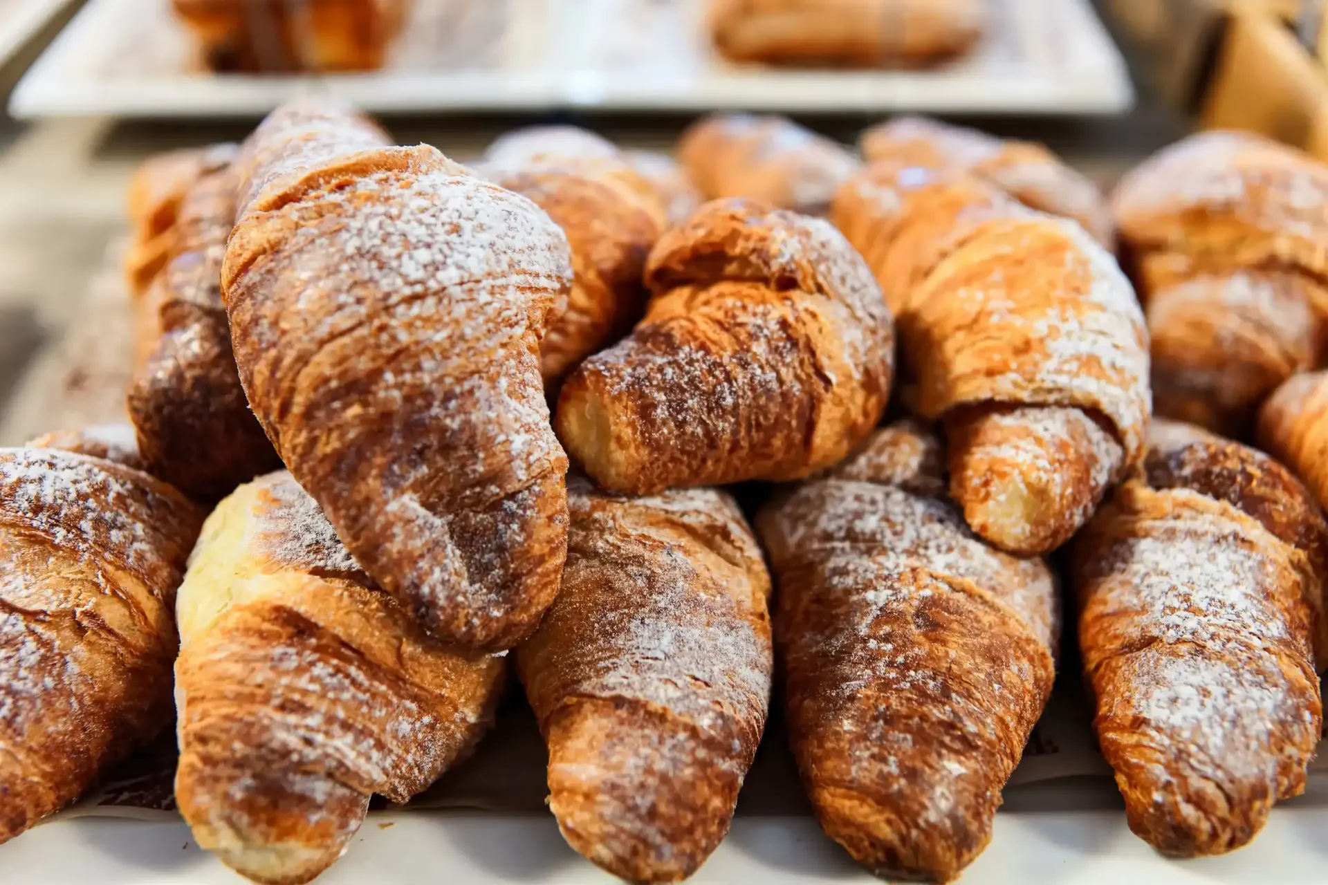 Un montón de croissants cubiertos de azúcar en polvo sobre una mesa.