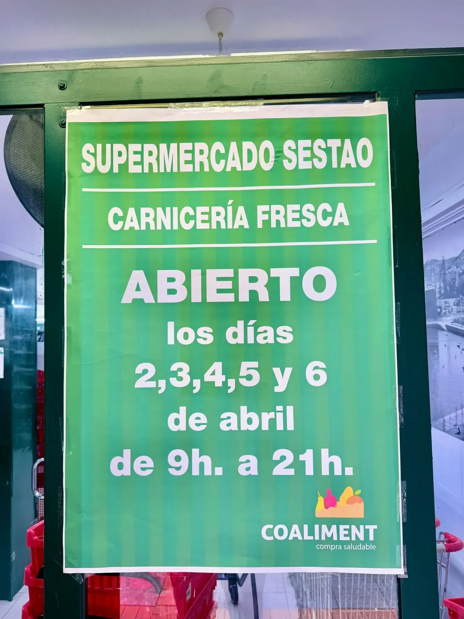 Un cartel verde en una puerta de cristal