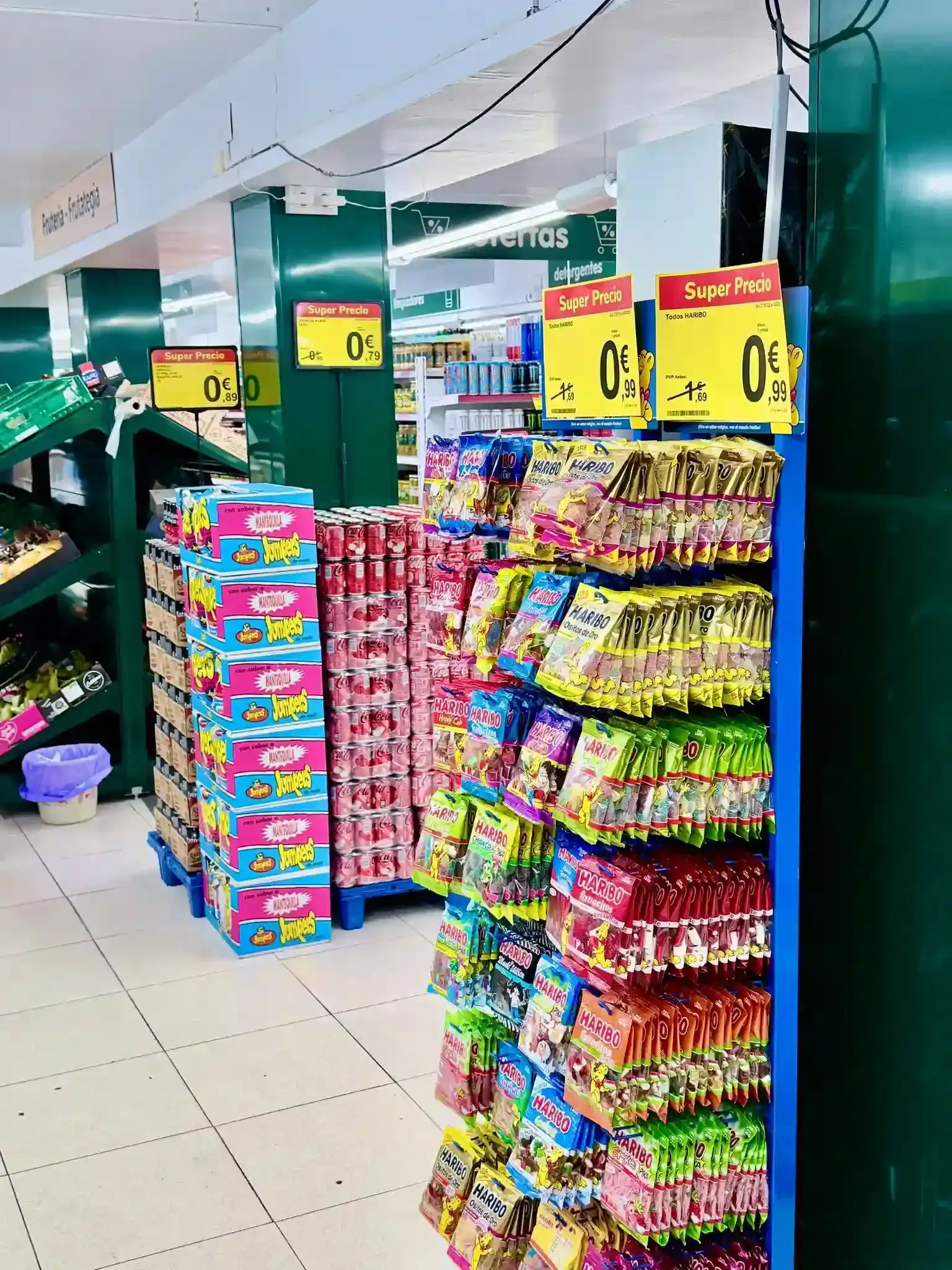 Un pasillo de supermercado con coloridas exhibiciones de bocadillos y dulces envasados en estantes de metal azul.