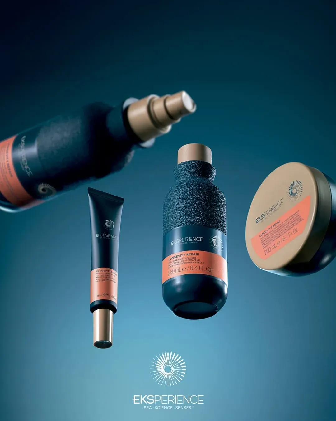 Productos de lujo para el cuidado de la piel en envases de color verde azulado y coral, dispuestos sobre un fondo azul.