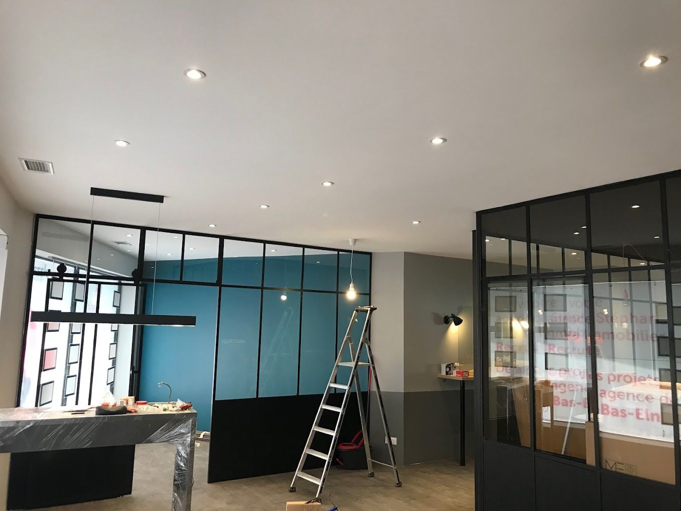 Installation en cours de luminaires au plafond pour des locaux