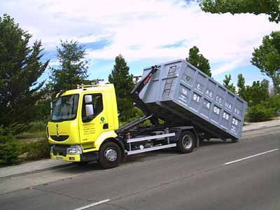 Un camión volquete amarillo está estacionado al costado de la carretera.