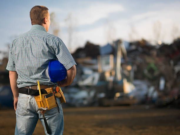 Un hombre está parado en un campo sosteniendo un casco azul.