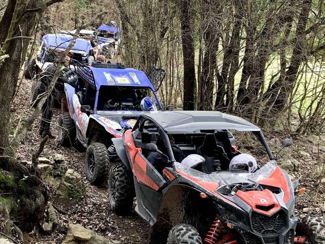 Los vehículos todoterreno recorren un estrecho y rocoso sendero forestal.