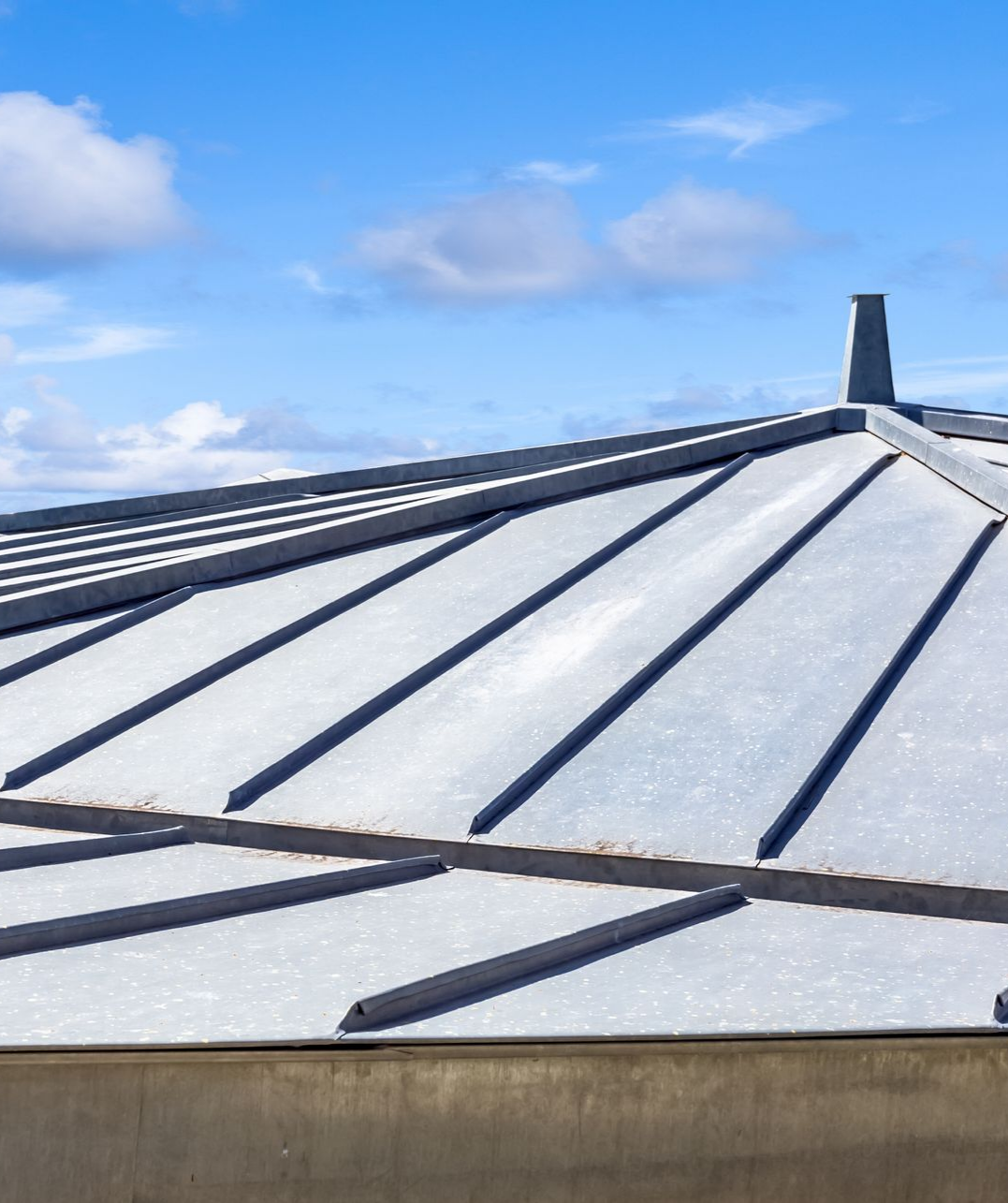 Toiture en zinc, sous un ciel bleu.