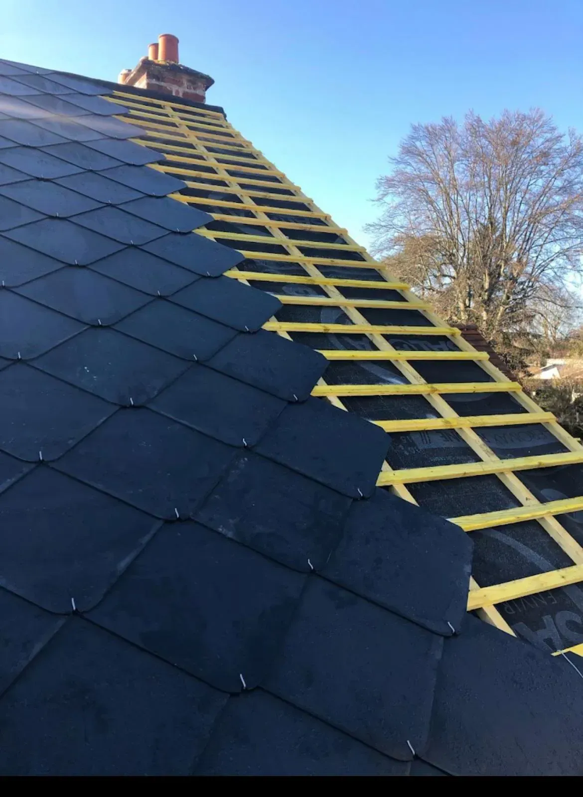 Toiture en cours de rénovation : revêtement partiellement installé.