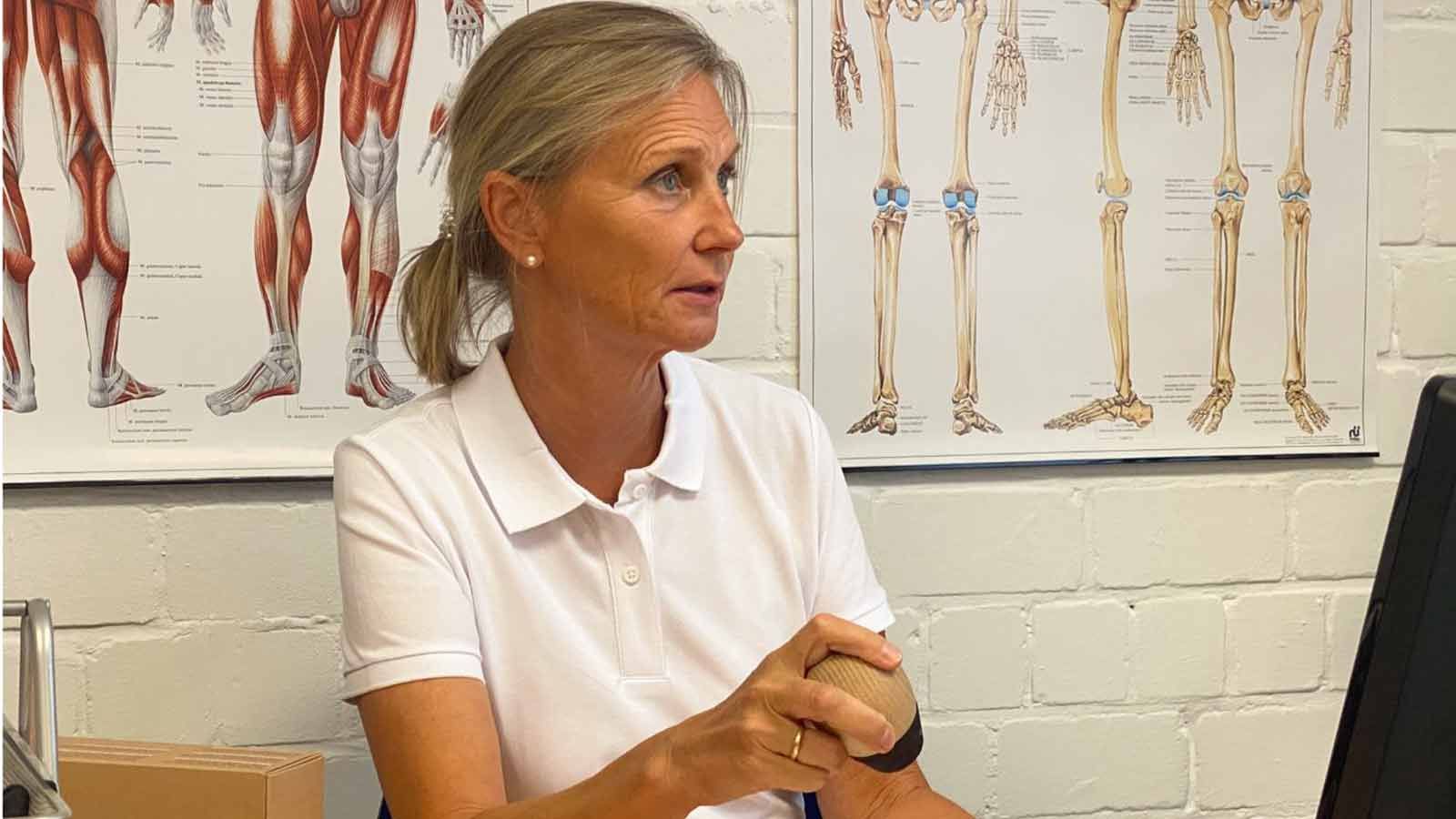 Eine Frau in einem weißen Hemd hält ein Augenmodell.