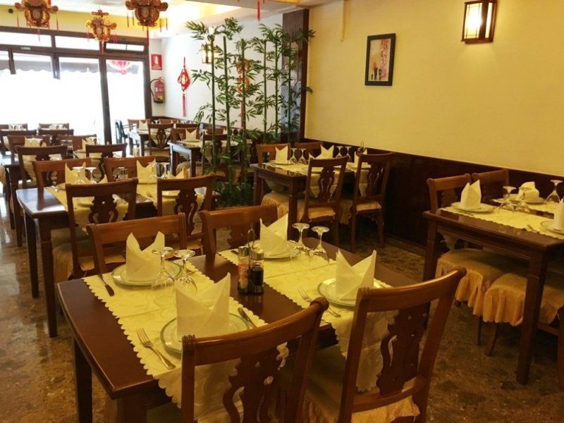 Un restaurante con muchas mesas y sillas