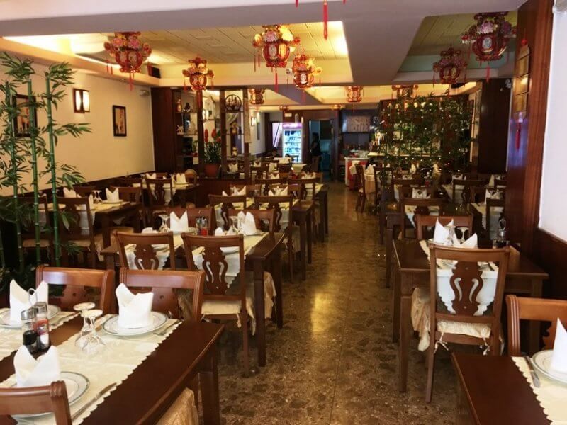 Un restaurante con muchas mesas y sillas