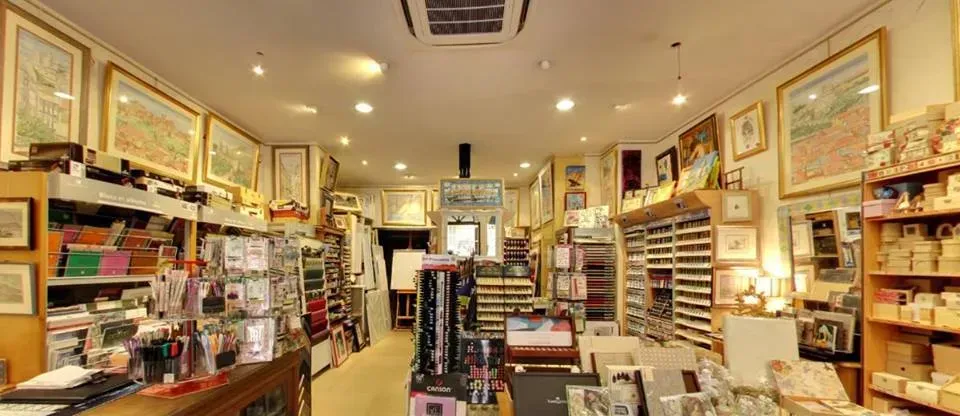 L'intérieur de la boutique avec des étagères sur lesquelles sont présentés des pinceaux et du matériel de dessin