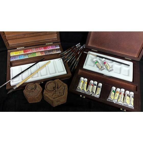 Des tubes de peintures et deux boîtes ouvertes sur une table